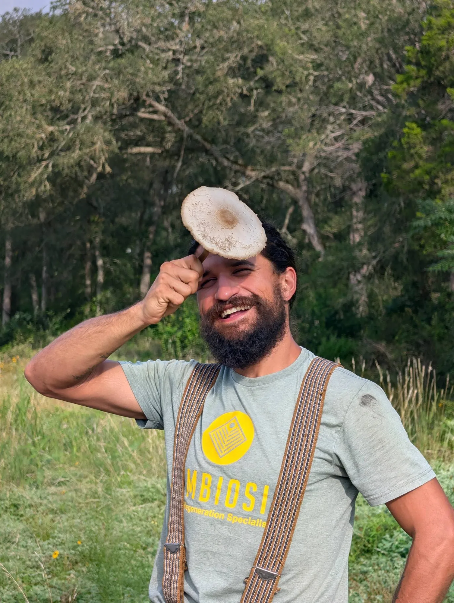 Sam the Fungi holding a foraged wild mushroom in a Central Texas meadow Sam the Fungi holding a foraged wild mushroom in a Central Texas meadow